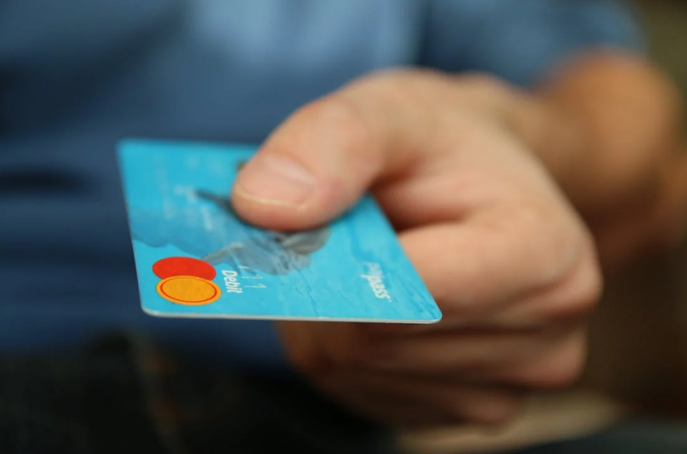 uomo con la sua carta di credito che usa per pagare tramite un codice promozionale MoneyGram