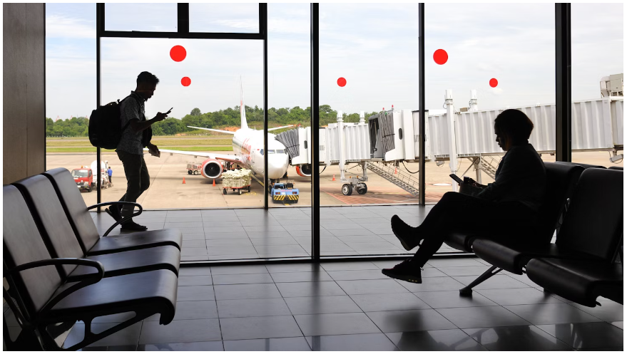 Two tourists in the airport awaiting their flight to their holiday destination