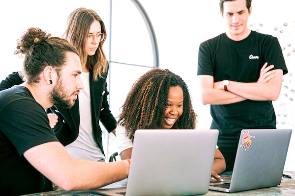 A group of people on their laptops looking for Joules promo codes sitting at a desk