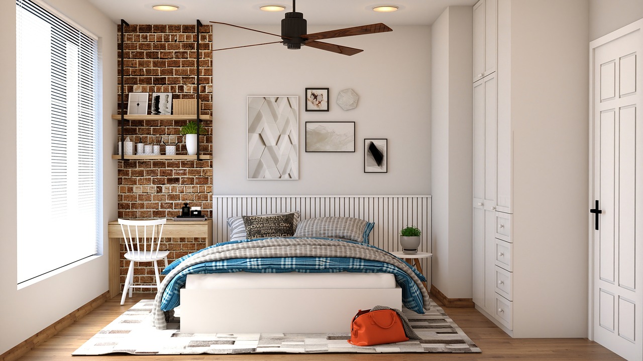 habitación con cama y colchón de varios colores y ropa de cama y mantas sobre la cama