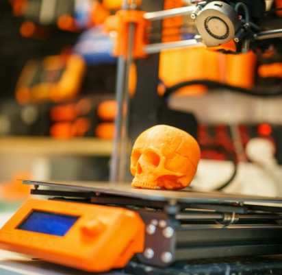 An orange skull on a weight scale after being printed on a Flashforge Adventurer 5M pro 3D printer