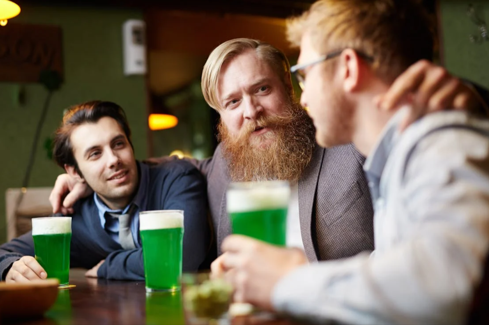 abbraccio tra amici mentre bevono birra comprata con un codice sconto St. Patrick's Day