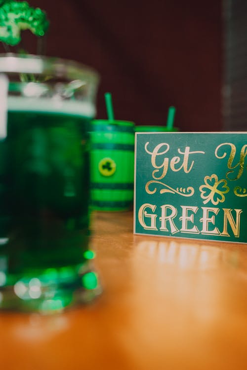 A few cups of gree alcohol with a "Get Green" sign in front of them