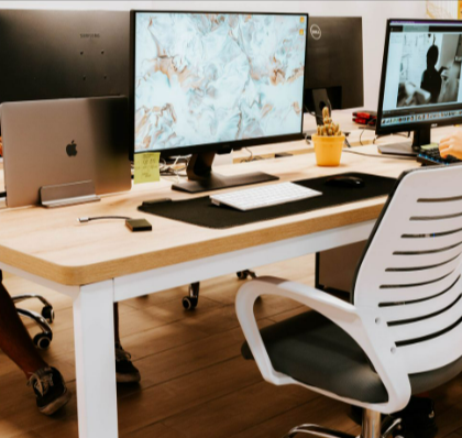 A professionally designed office setup with GEEKOM accessories, computers, monitors, and a stylish chair.