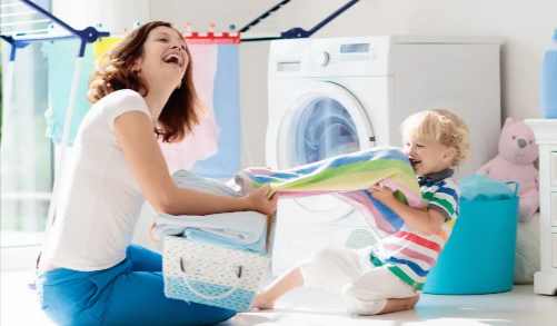 A mother and a son playing while doing laundry