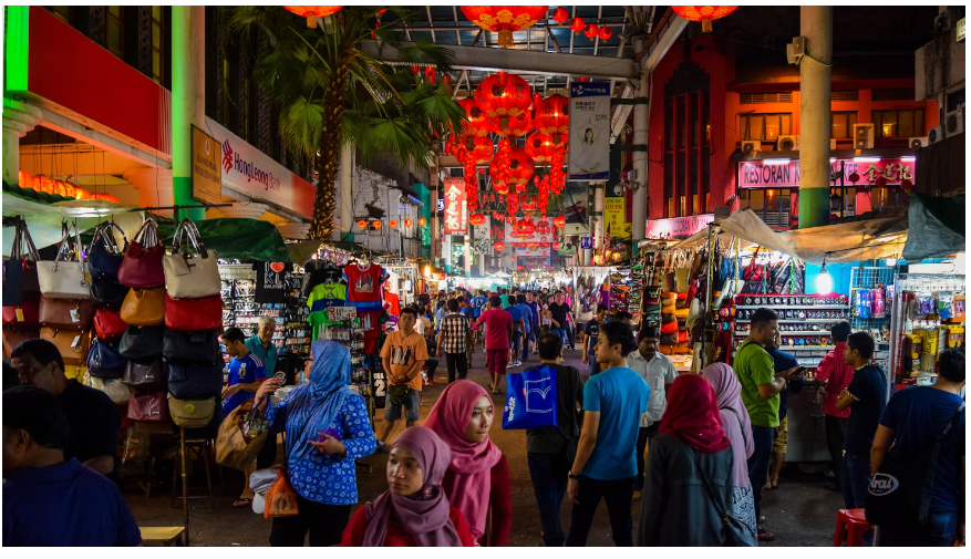 People walking on the street during a night street market with different stalls displayed