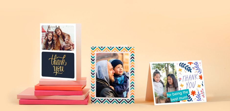 Colourful Touchnote cards and frames on display with a pink background