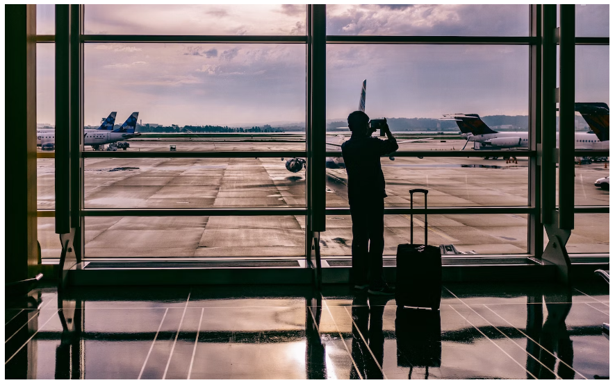 A traveller taking pictures of planes as he awaits to board with a travel promotion