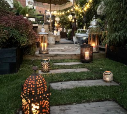 The Gardenstone concrete railway sleep stepping stones in a backyard with lights and an outdoor umbrella.