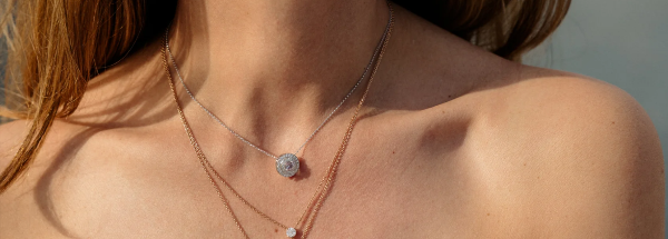 A woman's neck and chest, with two delicate necklaces
