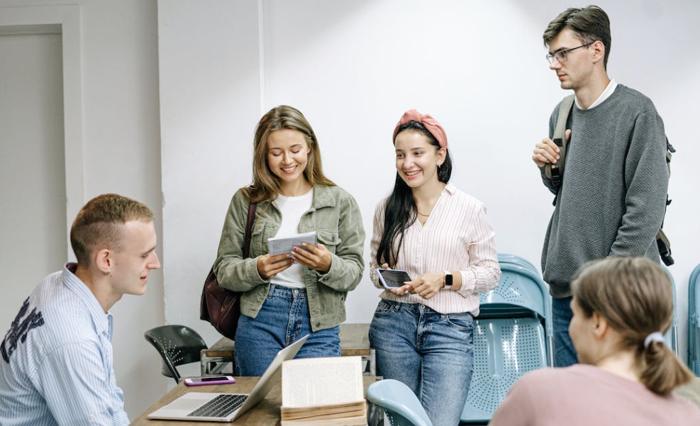 College students around a table and busy on a laptop finding Kaiser Kraft voucher codes