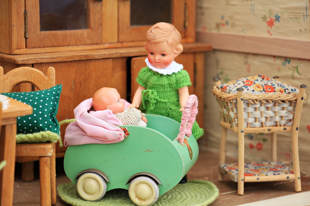 A toy doll house with doll bedding, chairs, cushions, and mat.