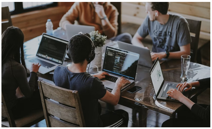 Five college students browsing on their laptops for the Maje discount code sale