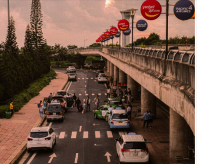 A busy airport entrance with private and shared shuttles from Holiday Taxis