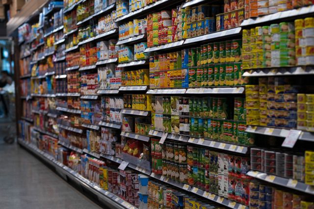 How to save money on food: A supermarket aisle with shelves of tinned food