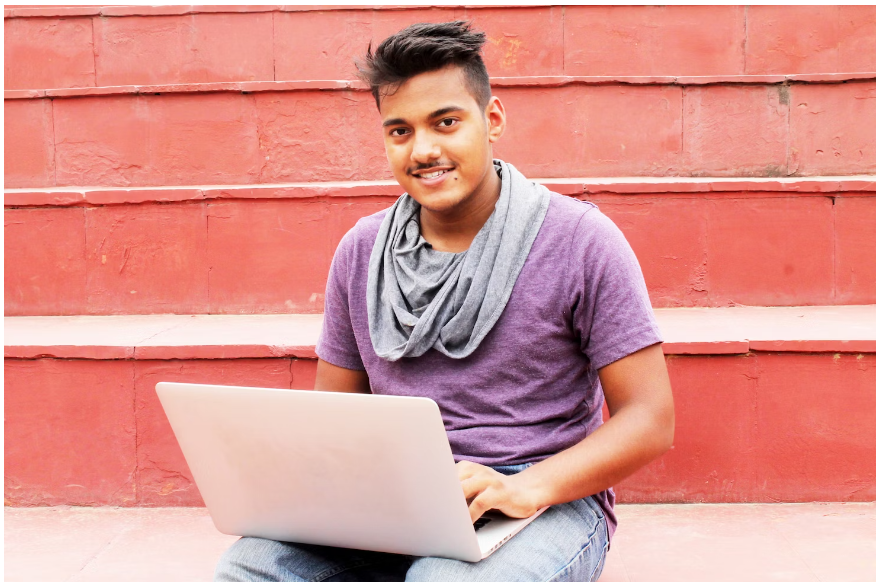 A male student browsing on his laptop for a Kapiva promo code to place his order