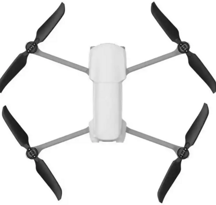A silver grey and black drone with four black wings at each corner and a small camera all on a white background