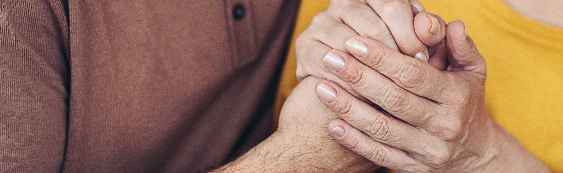 A younger person holding an older person's hand.