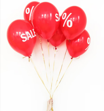 Red balloons with white sale signs and discounted percentages for Cyber Weekend