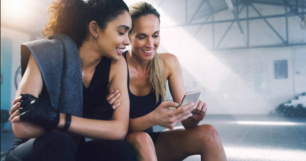 two athletes sitting down looking for the best P.E Nation voucher code during the break