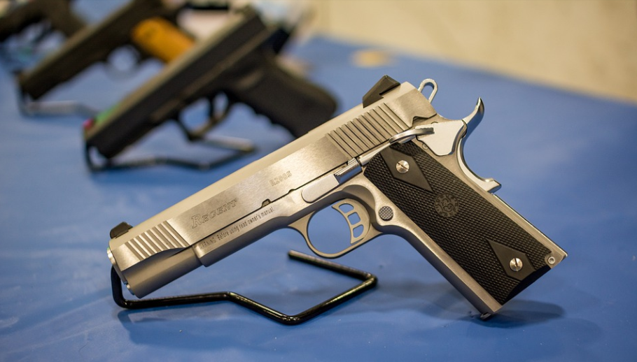 selection of firearms on a blue mat