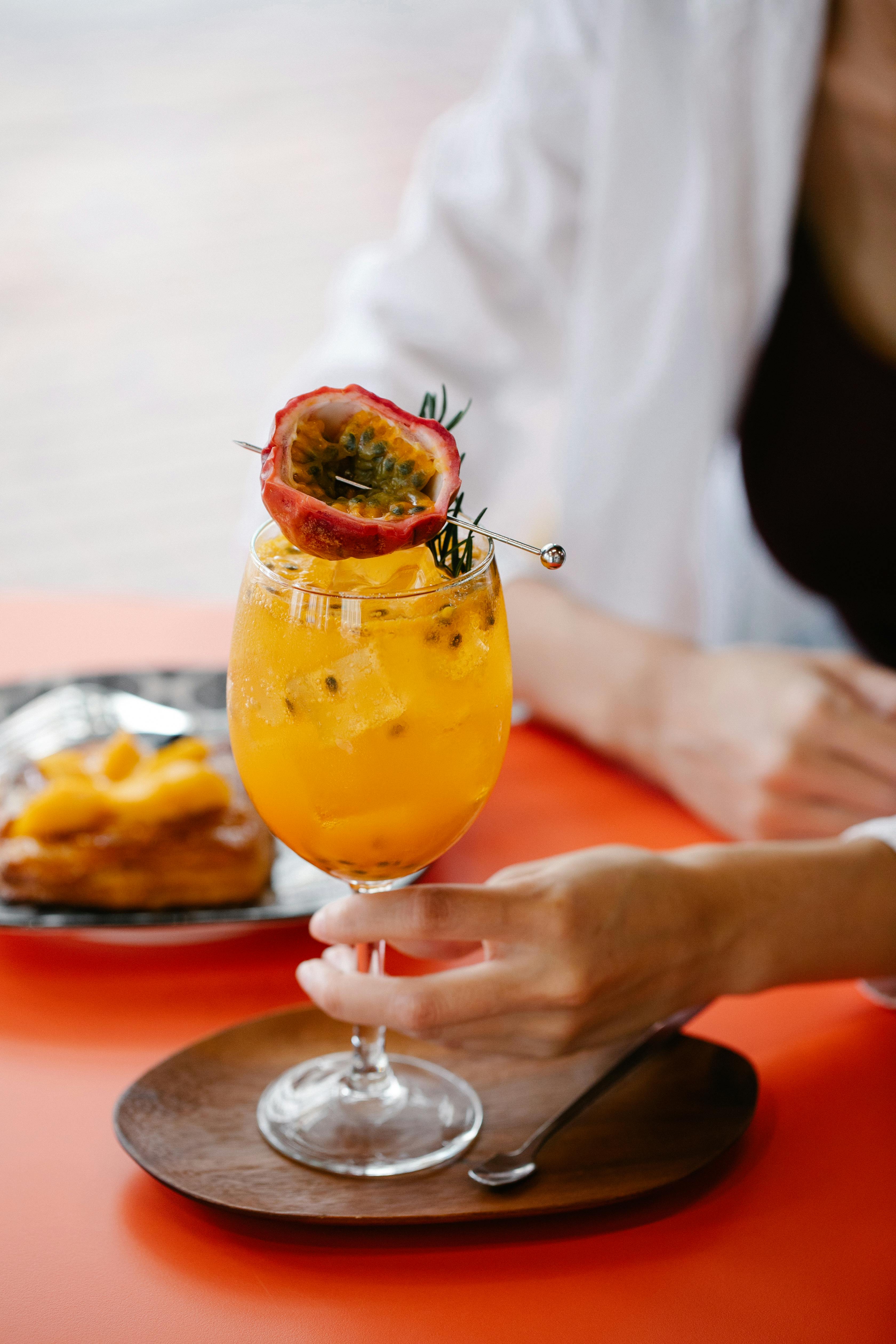 A fancy passion fruit mocktail in a wine glass with passion fruit garnish.