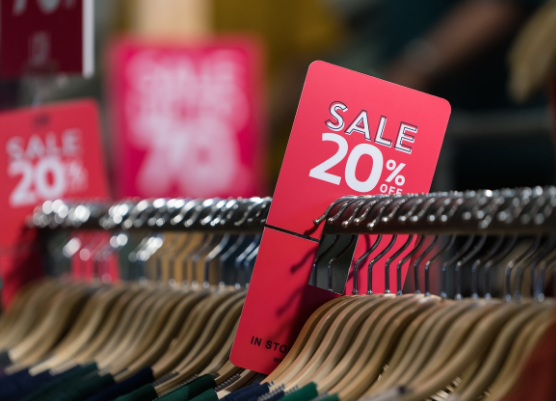 perchas de ropa y ropa en tienda con código descuentos de rebajas de enero