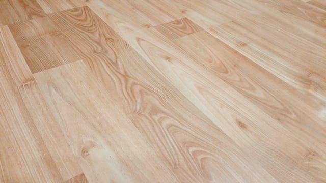 Lightly stained brown vinyl wooden flooring arranged in a plank formation
