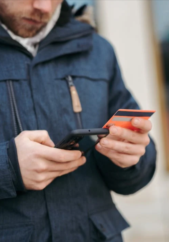 uomo che usa un promo code MoneyGram tramite la sua carta di credito per effettuare trasferimento di denaro