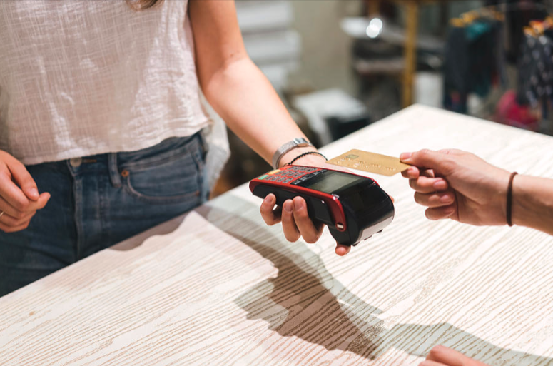 Payment from a customer in a clothing store using a card with the card machine for their purchase