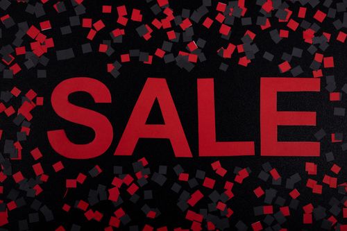 A red banner saying "Sale" with red and black confetti around it