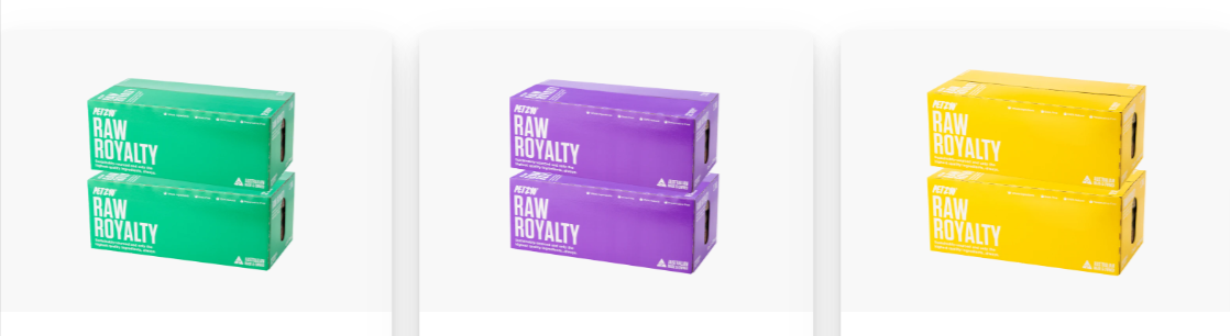 Three boxes of Petzyo raw dog food that are green, purple and yellow on a white background