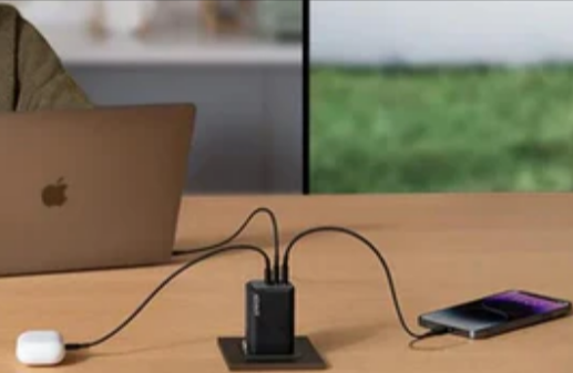 An Anker 3 port charger charging an iPhone, Macbook and airpods 