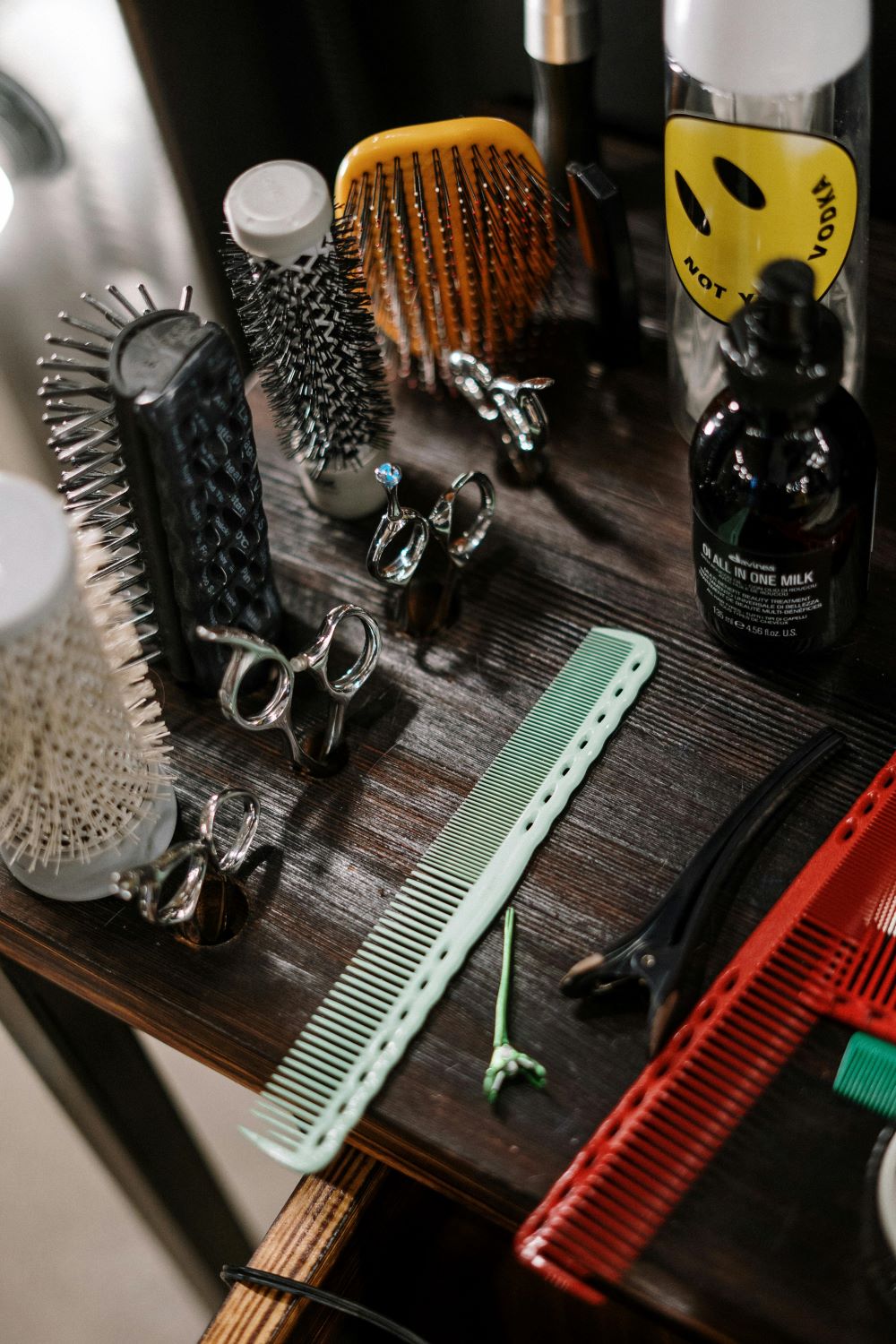 Four different types of hair types, hair combs, and hair scissors on a wooden table.