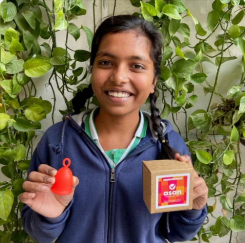 A young girl holding the Asan menstrual cup