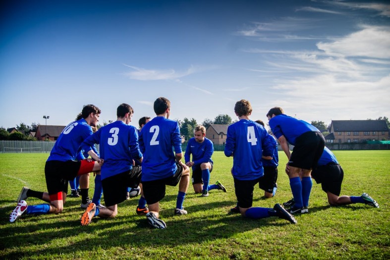 gruppo di amici che giocano a calcio con abbigliamento sportivo da uomo comprato con un promo code Sports Direct
