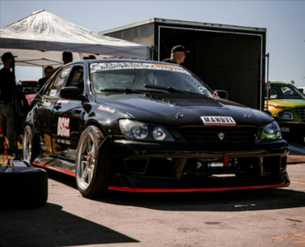 A parked black sports car on the race track