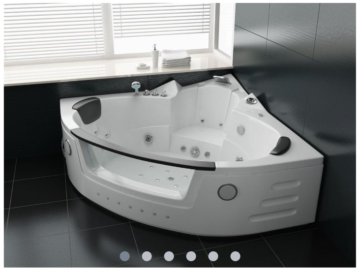 Eine weiße Whirlpool-Badewanne in einer Ecke verbaut mit dunklen Fließen