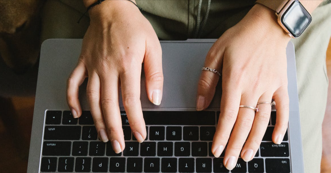 Hand typing on a black keyboard. Person is looking for a eBay discount coupon.