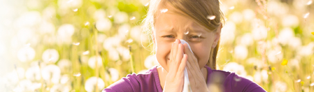 A little girl blowing her noise in a field of dandilions