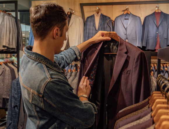 A man looking for a cheap men's suit inside a suit store