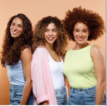 Three women with different textures of curly and wavy hair