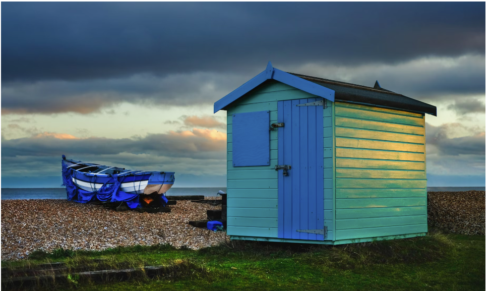 A blue and teal wooden shed at the beach