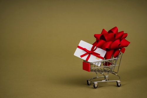 A GoGroopie voucher code in a trolley with a red ribbon next to it