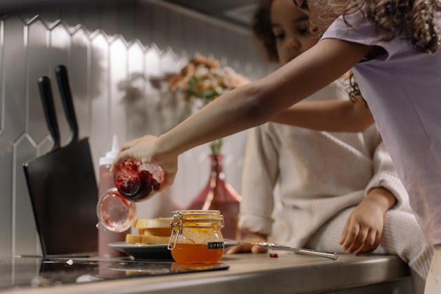 Activities for Father's Day: Two little girls preparing jam sandwiches