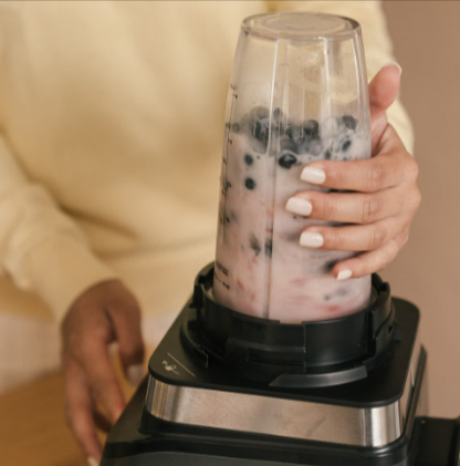 A woman blending a nutritious berry smoothie in a kitchen with a Ninja bullet from Go Electrical