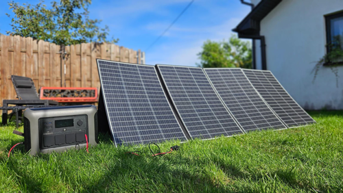 Eine Power-Station und mehrere Solar-Panels auf einem Rasen neben einem Haus