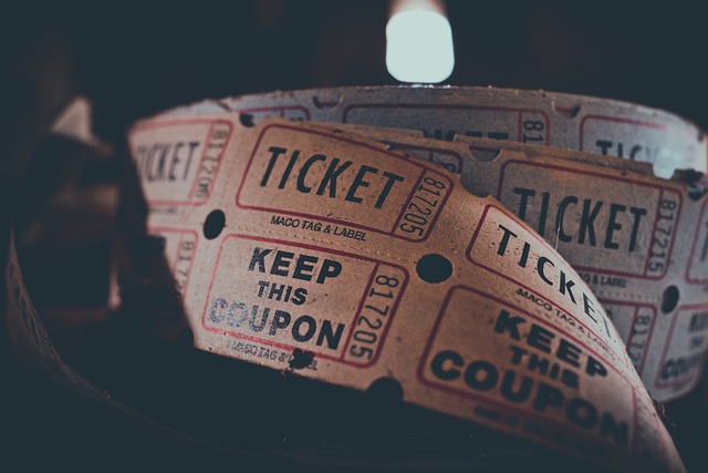 An unwound roll of cheap cinema tickets under a spotlight against a dark background