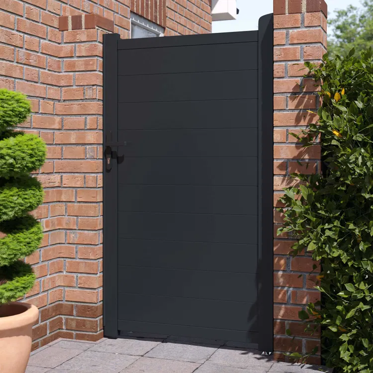 black gate/door on an outdoor brick wall with plants