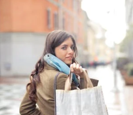 ragazza con in mano delle buste mentre compra prodotti in offerta con i codici sconto Saldi di Gennaio